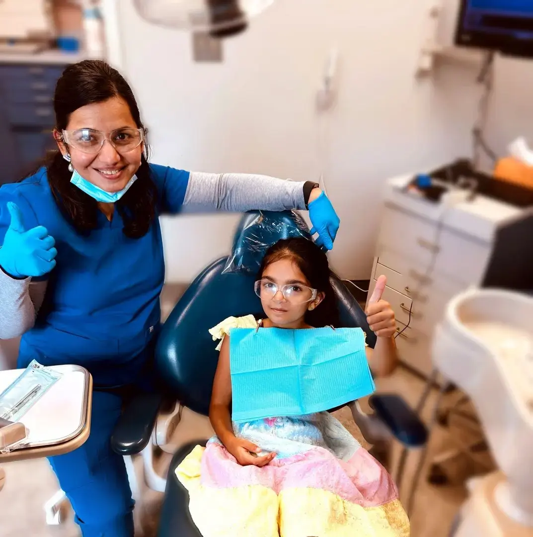 Dental professional and young patient give thumbs up in a Montville, NJ dental office